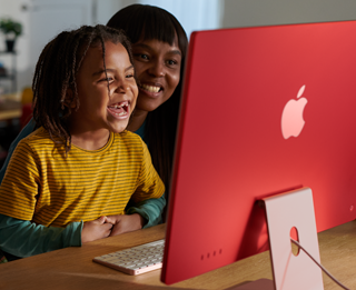 Các thành viên trong gia đình đang cười cùng nhau khi xem một chương trình trên iMac.